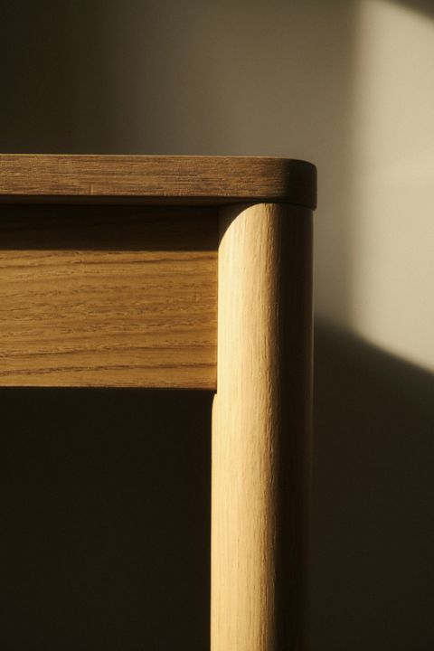 Gerundete Kante eines Holzmöbels im warmen Licht